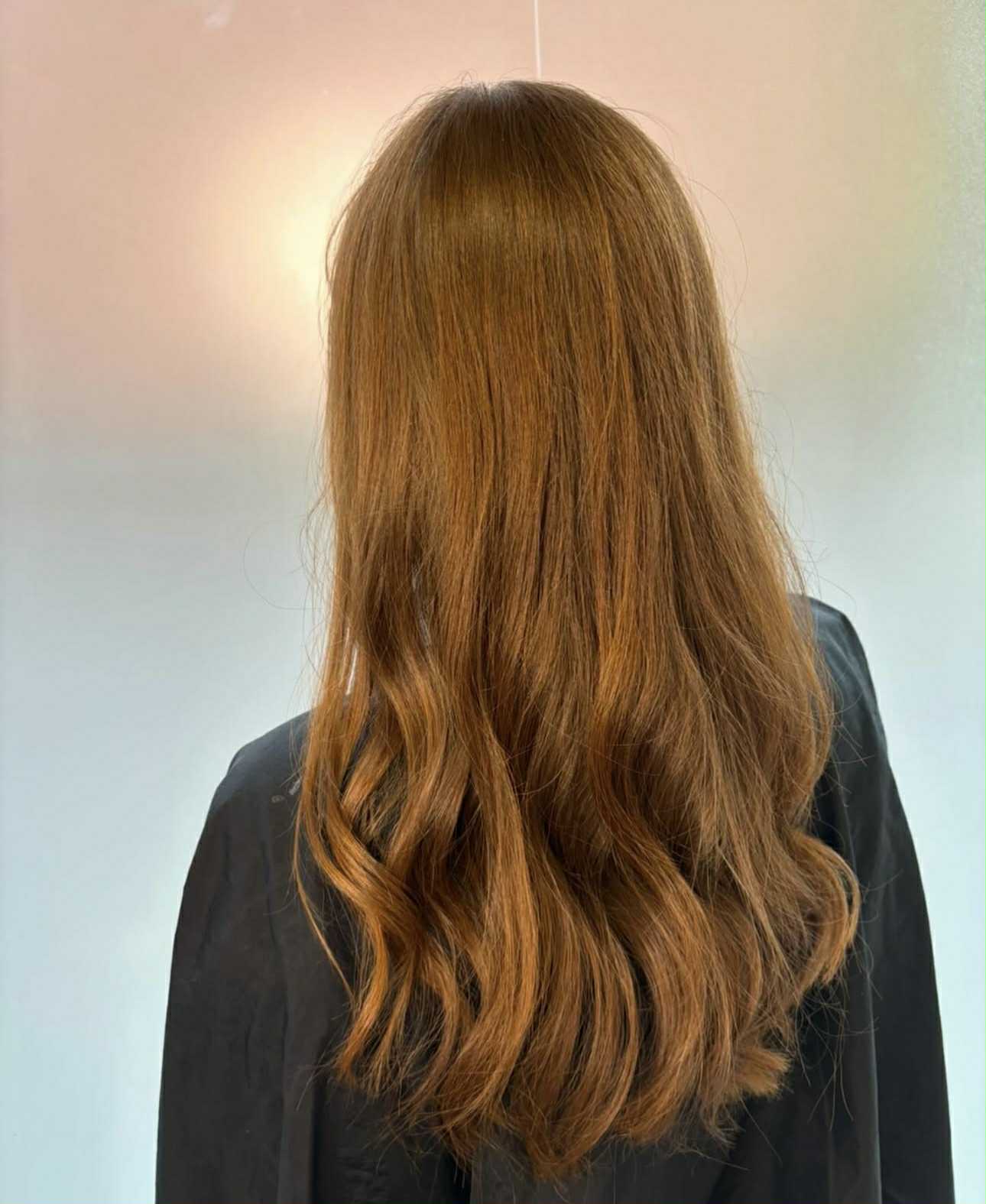 Langt brunt hår, med gyldent skær, efter dameklip og styling
